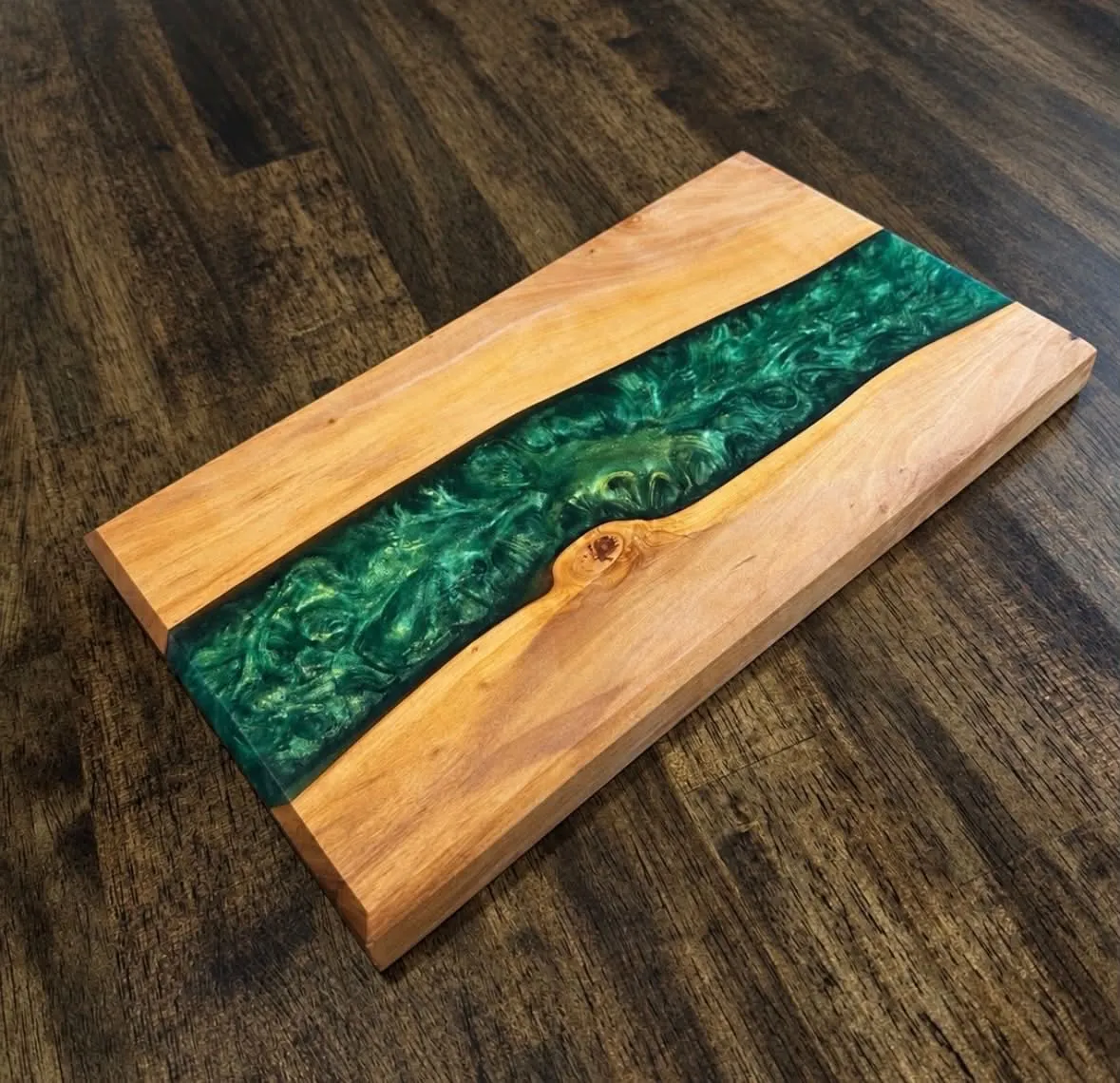 Wooden board with a swirling green epoxy river between two wood sections